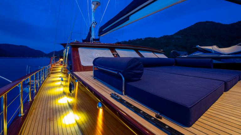The deck of the S/Y Voyage gulet. Twilight. Sun beds can be seen