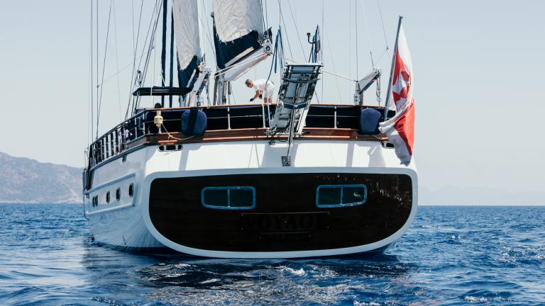 Rear view of the S/Y Voyage gulet on the sea. Man on board