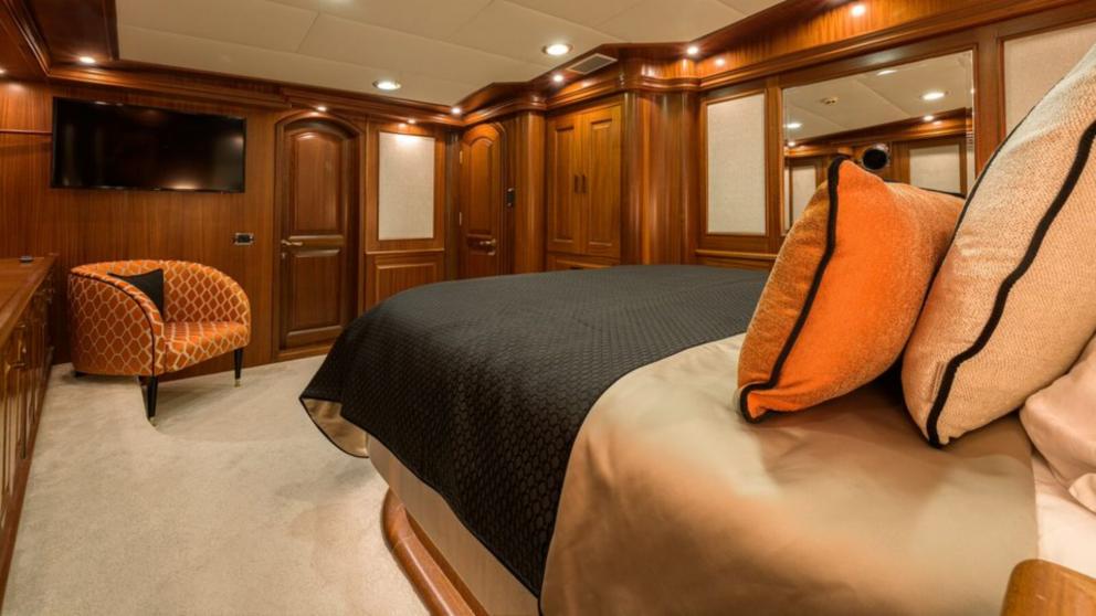 Ein geräumiges Schlafzimmer auf der Kaptan Kadir Gulet. Sie können die Wände aus Holz, einen Fernseher und einen Sessel