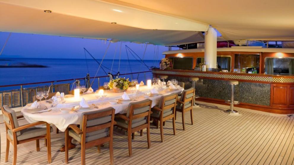 Ein luxuriös servierter Tisch auf einer Yacht. Abendzeit, Kerzen auf dem Tisch