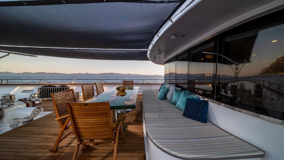 Foredeck dining and seating area on the front deck of luxury motor yacht Olimp