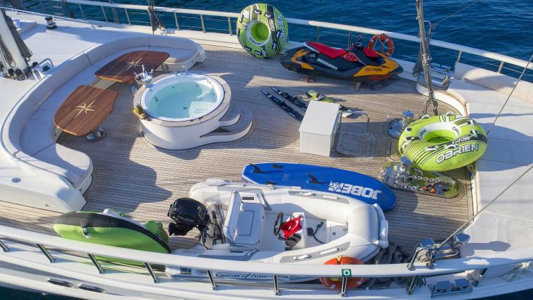 Deck with water equipment. A jet ski, dinghy and inflatables can be seen