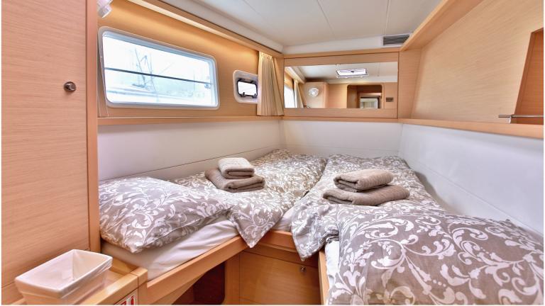 Bright catamaran guest cabin with mirror and window