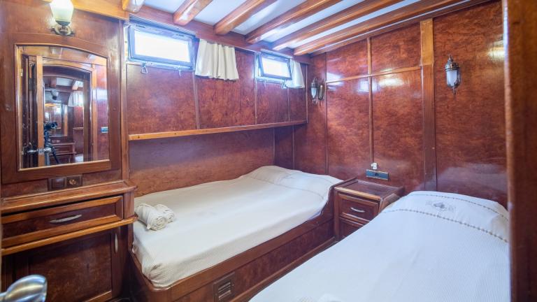 Double cabin with separate beds. You can see portholes and a mirror