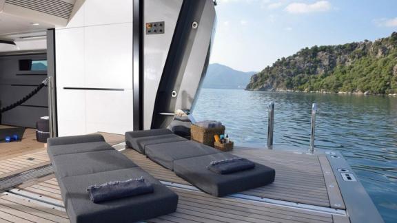 The usage area on the swimming platform of the Fx motor yacht and two sun beds.
