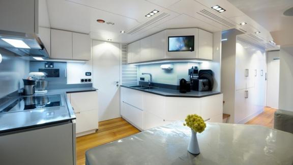 A large yacht kitchen with a television and a large usage area.