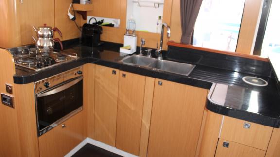 Catamaran kitchen designed with the harmony of black and wood.