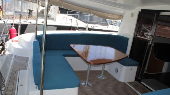 Outdoor shade area and dining table of a 44-feet rental catamaran.