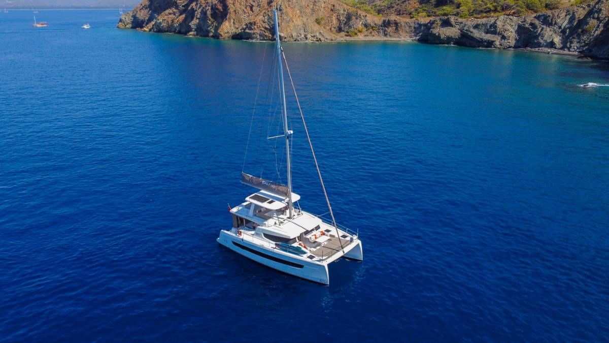 The catamaran in the middle of the blue sea is waiting for its next voyage.